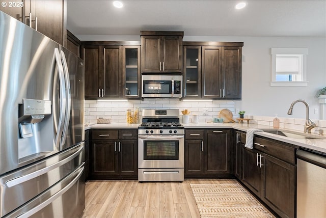 kitchen featuring a sink, light countertops, dark brown cabinetry, and stainless steel appliances