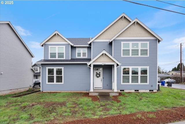 craftsman inspired home with roof with shingles and a front lawn