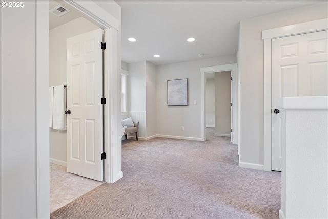 hall featuring visible vents, recessed lighting, baseboards, and light carpet