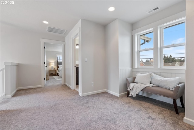 sitting room with recessed lighting, visible vents, carpet floors, and wainscoting