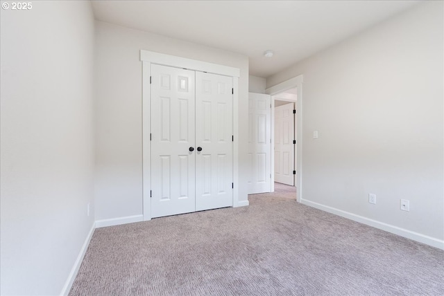 unfurnished bedroom with a closet, baseboards, and carpet