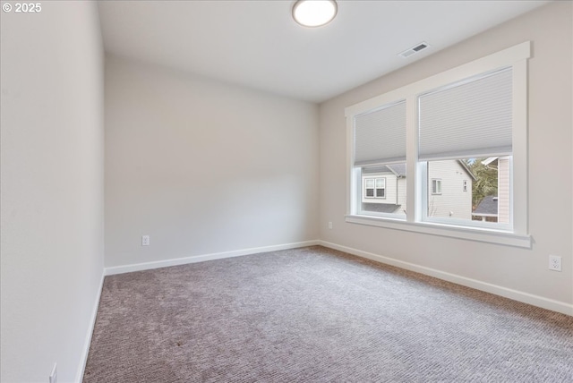 spare room featuring visible vents, baseboards, and carpet floors