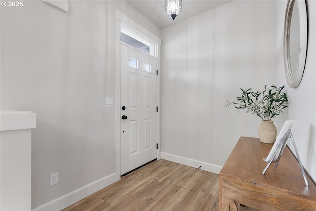 foyer entrance with light wood-style floors and baseboards