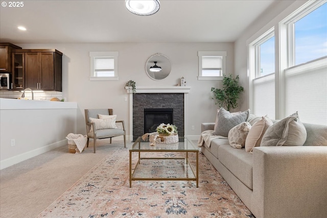 living room featuring light carpet, recessed lighting, a fireplace, and baseboards