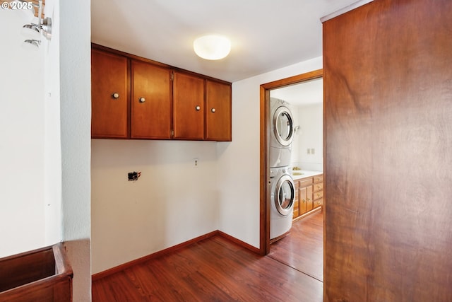 6901 SE Oaks Park Way Unit 1, Portland, OR 97202 - laundry area with cabinet space, estacked washer and dryer, dark wood-type flooring, and baseboards
