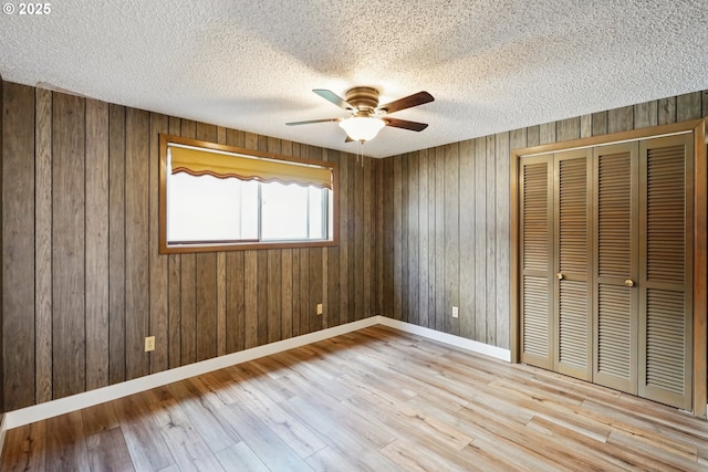 6901 SE Oaks Park Way Unit 1, Portland, OR 97202 - unfurnished bedroom featuring a closet, wood finished floors, a textured ceiling, wood walls, and baseboards