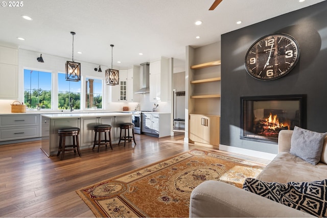 19428 NE 259th St, Battle Ground, WA 98604 - living area with dark wood finished floors, recessed lighting, a glass covered fireplace, ceiling fan, and built in shelves