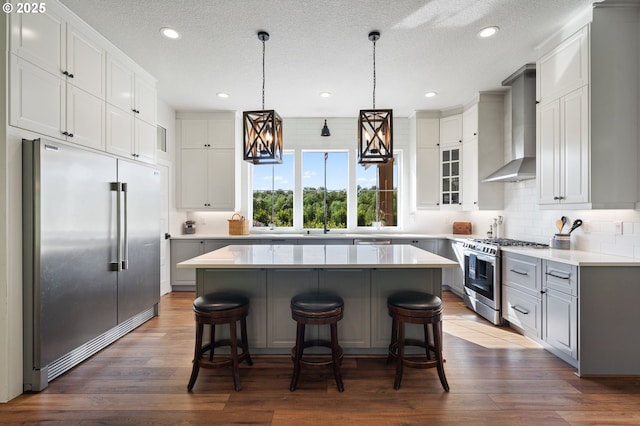 19428 NE 259th St, Battle Ground, WA 98604 - kitchen with appliances with stainless steel finishes, wall chimney range hood, a center island, a kitchen breakfast bar, and recessed lighting