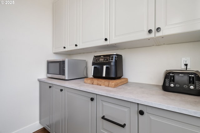 19428 NE 259th St, Battle Ground, WA 98604 - detailed view of stainless steel microwave, light countertops, white cabinetry, and baseboards
