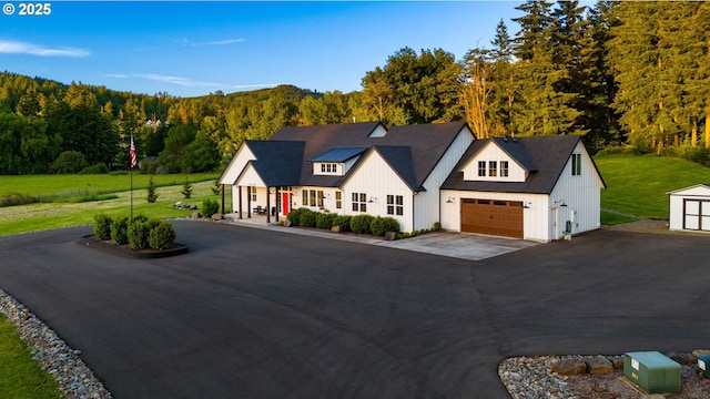 19428 NE 259th St, Battle Ground, WA 98604 - modern inspired farmhouse featuring board and batten siding, asphalt driveway, a garage, and a view of trees