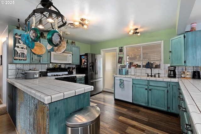 2903 N Spruce St, La Grande, OR 97850 - kitchen with white appliances, a sink, backsplash, tile countertops, and dark wood finished floors