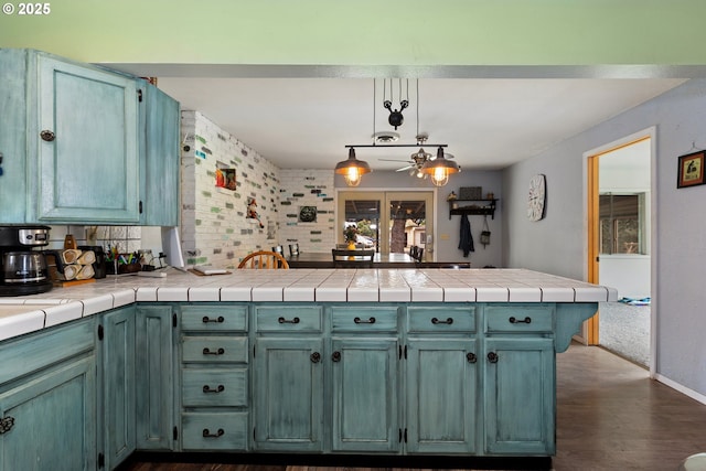 2903 N Spruce St, La Grande, OR 97850 - kitchen featuring a peninsula, dark wood-style floors, baseboards, pendant lighting, and decorative backsplash