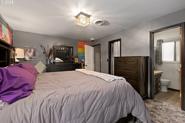 2903 N Spruce St, La Grande, OR 97850 - bedroom featuring wood finished floors, connected bathroom, and a textured wall