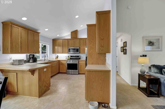 5986 Rombauer Rd, Eugene, OR 97402 - kitchen with appliances with stainless steel finishes, a peninsula, light countertops, vaulted ceiling, and a kitchen bar