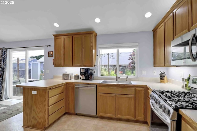 5986 Rombauer Rd, Eugene, OR 97402 - kitchen featuring appliances with stainless steel finishes, a peninsula, light countertops, recessed lighting, and brown cabinets