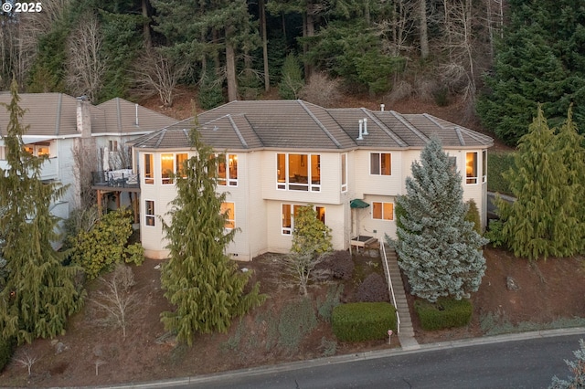 view of front of home with a tile roof and a balcony