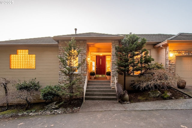 prairie-style house with stone siding and a tile roof