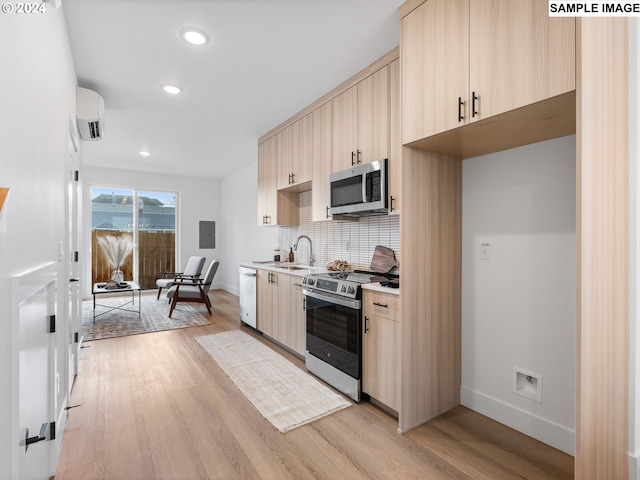 kitchen with stainless steel appliances, light brown cabinets, light countertops, and decorative backsplash