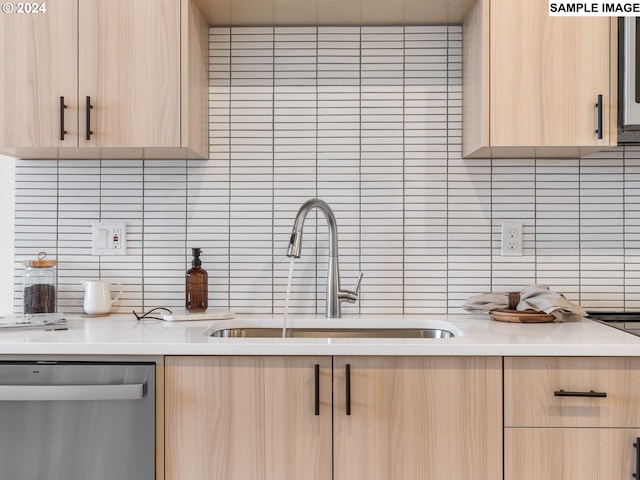 kitchen with decorative backsplash, dishwasher, a sink, and light brown cabinetry