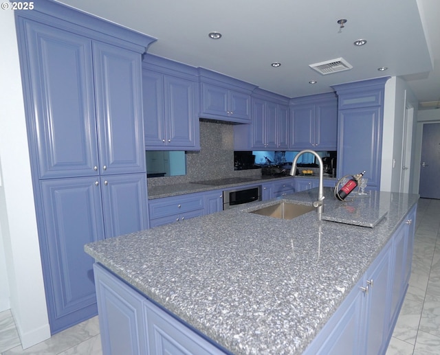 1260 NW Naito Pkwy Unit 604B, Portland, OR 97209 - kitchen with a sink, marble finish floor, a large island with sink, backsplash, and visible vents