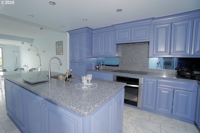 1260 NW Naito Pkwy Unit 604B, Portland, OR 97209 - kitchen with a kitchen island with sink, oven, black electric cooktop, blue cabinets, and a sink