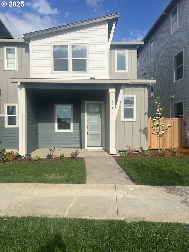 view of front of home with board and batten siding, a porch, and fence