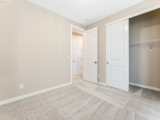 unfurnished bedroom with carpet, baseboards, and a closet