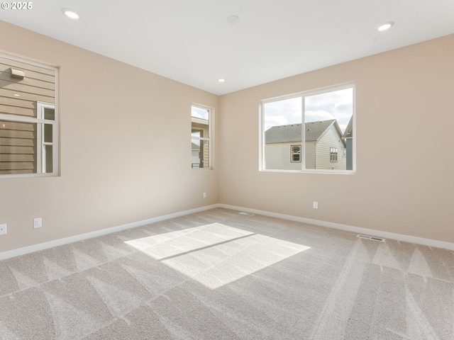carpeted empty room with baseboards and recessed lighting