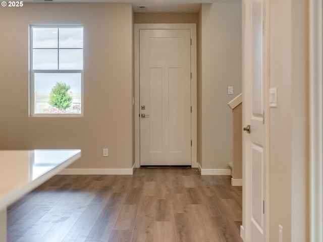 entryway with light wood-style flooring and baseboards