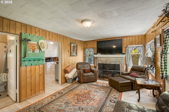 26630 E Roberts Rd, Welches, OR 97067 - living area with wood walls, a stone fireplace, and light wood-style flooring