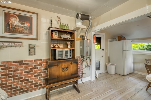26630 E Roberts Rd, Welches, OR 97067 - kitchen featuring freestanding refrigerator, water heater, light wood-style flooring, and baseboards