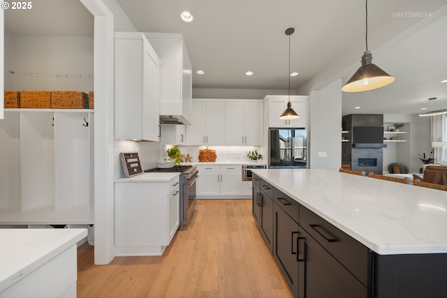 kitchen featuring white cabinets, appliances with stainless steel finishes, a center island, backsplash, and hanging light fixtures