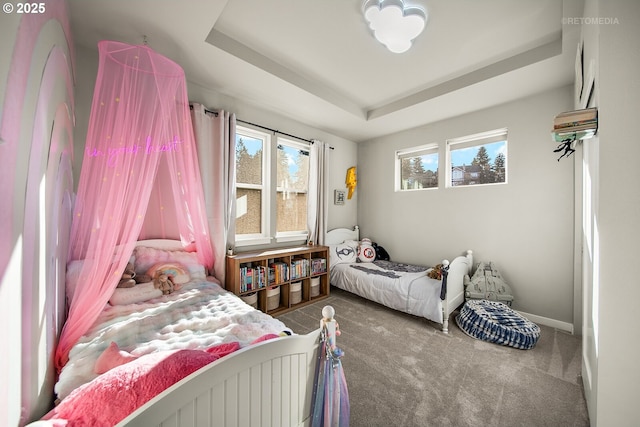 bedroom with a tray ceiling and carpet flooring