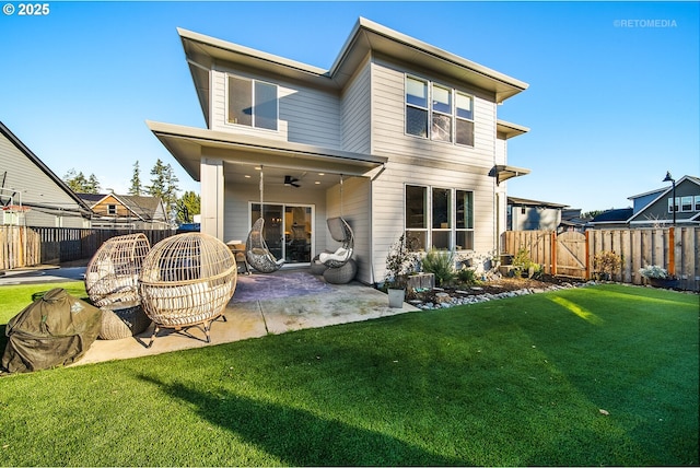 rear view of house featuring ceiling fan, a patio, and a yard