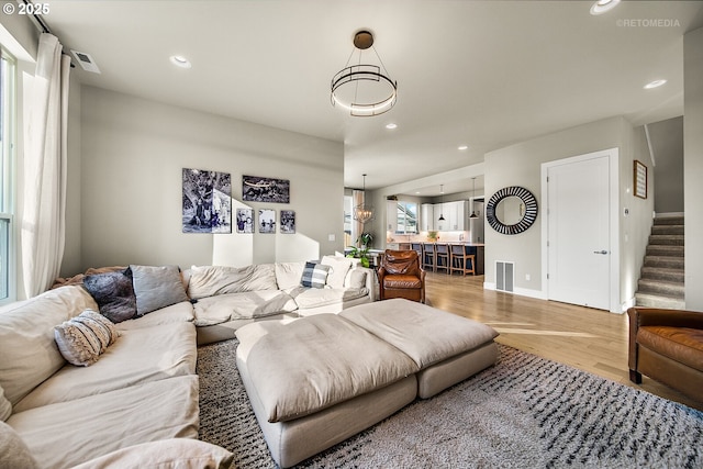 living room featuring hardwood / wood-style flooring and an inviting chandelier