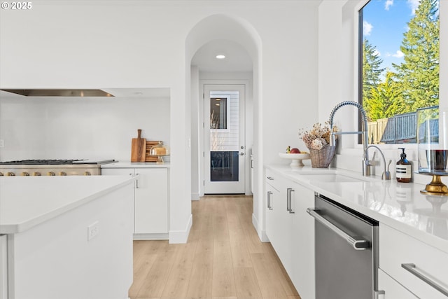 kitchen with white cabinetry, appliances with stainless steel finishes, light hardwood / wood-style floors, and sink