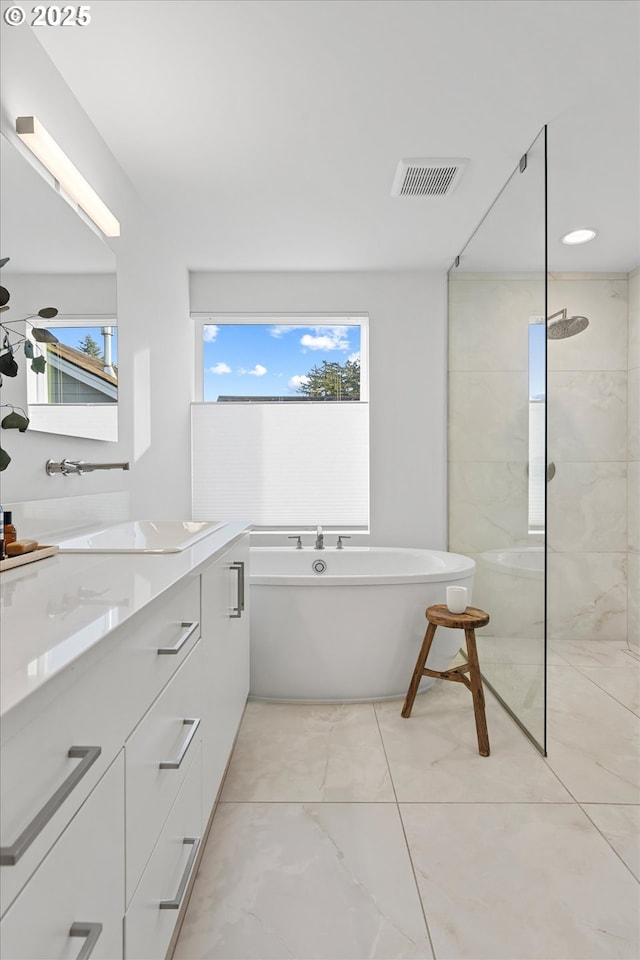 bathroom with vanity, plenty of natural light, and tiled shower