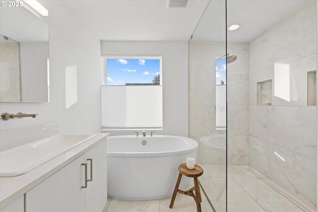 bathroom featuring independent shower and bath, vanity, and tile patterned floors