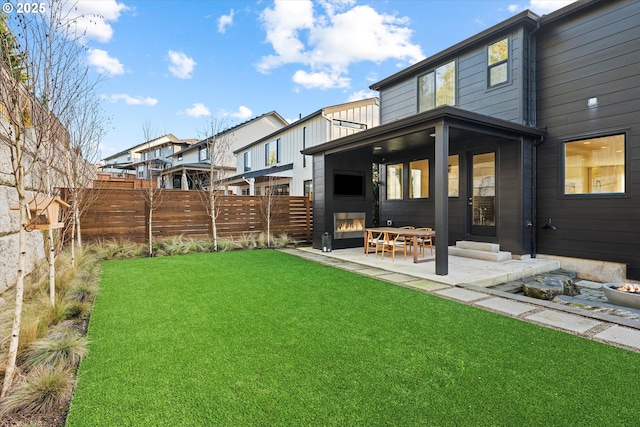 rear view of house featuring a yard and a patio