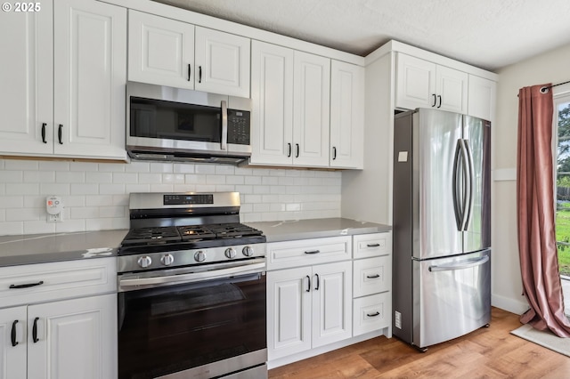 545 N St, Castle Rock, WA 98611 - kitchen with stainless steel appliances, white cabinetry, and backsplash