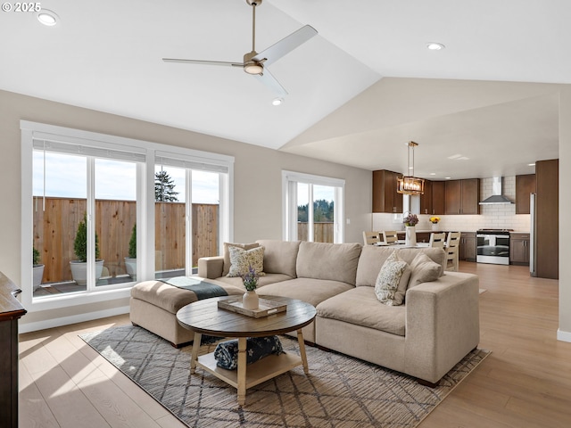 35692 Bella Ridge Loop, Astoria, OR 97103 - living area with light wood-type flooring, vaulted ceiling, recessed lighting, and ceiling fan with notable chandelier