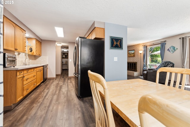 8312 SW Tygh Loop, Tualatin, OR 97062 - dining room featuring dark wood-style flooring, a fireplace, and a textured ceiling