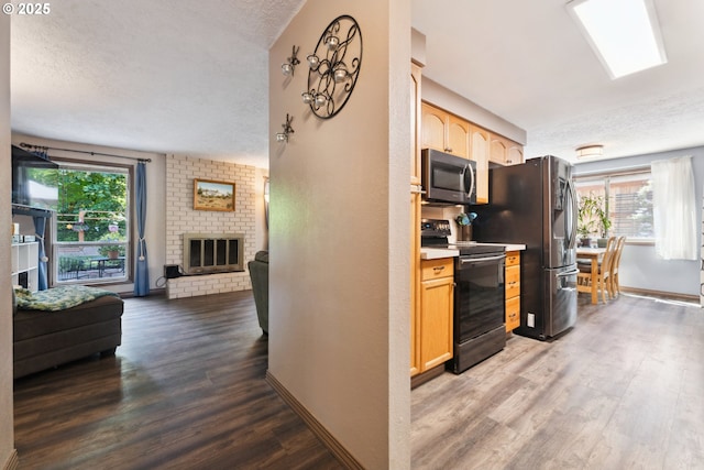 8312 SW Tygh Loop, Tualatin, OR 97062 - kitchen featuring stainless steel appliances, a textured ceiling, light brown cabinets, open floor plan, and wood finished floors