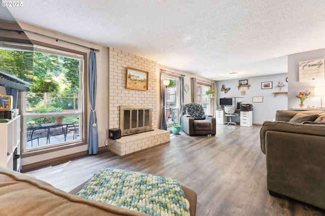 8312 SW Tygh Loop, Tualatin, OR 97062 - living area with a textured ceiling, an office area, wood finished floors, a brick fireplace, and baseboards