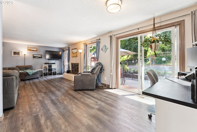 8312 SW Tygh Loop, Tualatin, OR 97062 - living area with dark wood-type flooring, a textured ceiling, and a brick fireplace