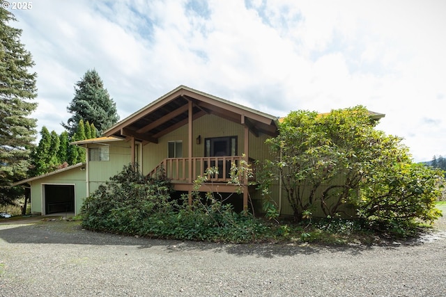chalet / cabin with a garage and gravel driveway