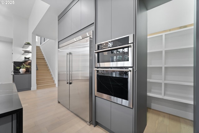 kitchen with light wood finished floors, appliances with stainless steel finishes, and modern cabinets