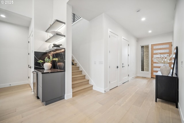 entryway with recessed lighting, baseboards, stairs, and light wood-style floors