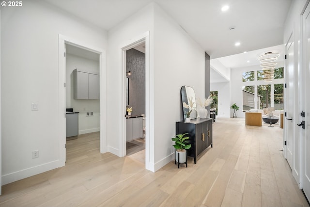 corridor featuring recessed lighting, light wood-type flooring, and baseboards