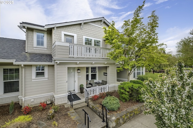 craftsman inspired home with a porch, a balcony, and roof with shingles